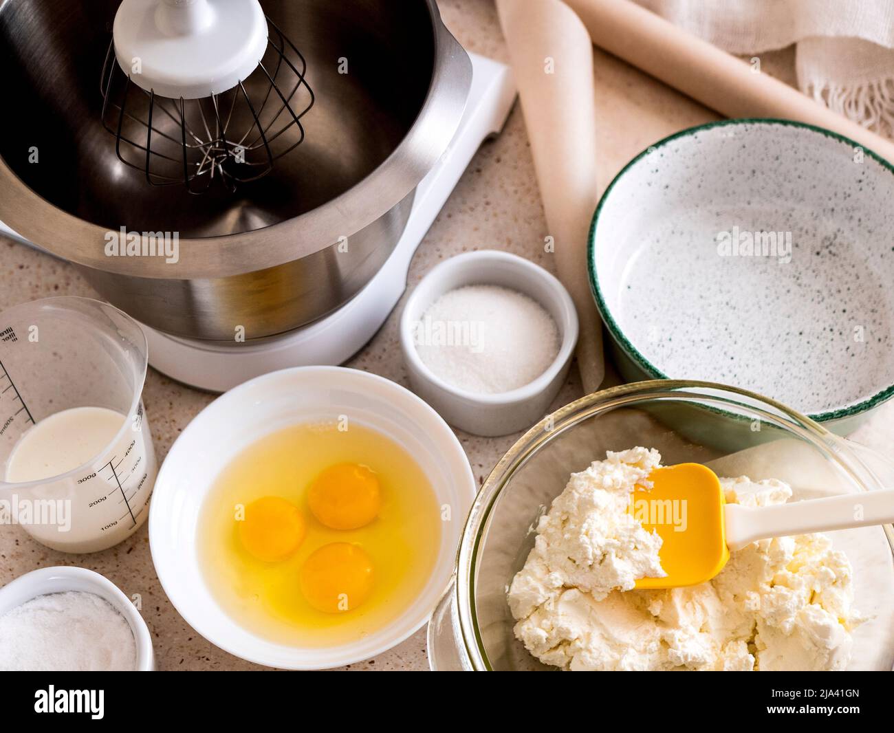 Zutaten für die Herstellung von Käsekuchen: Eier, Käse, Zucker, Milchcreme. Hausmannskost während der Quarantäne, selektiver Fokus Stockfoto