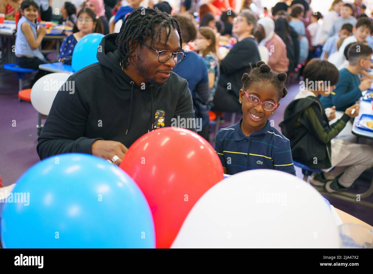 Eltern und Kinder genießen ein großes Jubilee-Mittagessen an der Duncombe Primary School im Norden Londons. Bilddatum: Freitag, 27. Mai 2022. Stockfoto