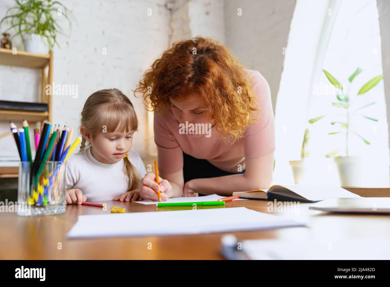 Einzelunterricht im Zentrum der frühen Entwicklung der Kinder. Professionelle Therapeutin kommuniziert mit dem Kind während außerschulischer Aktivitäten. Stockfoto