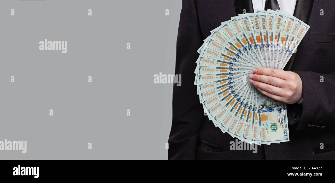 Business, Banking, Finance und Sparkonzept. US-Dollar-Geldscheine von hundert Dollar Scheine in der Hand eines Geschäftsmannes Stockfoto
