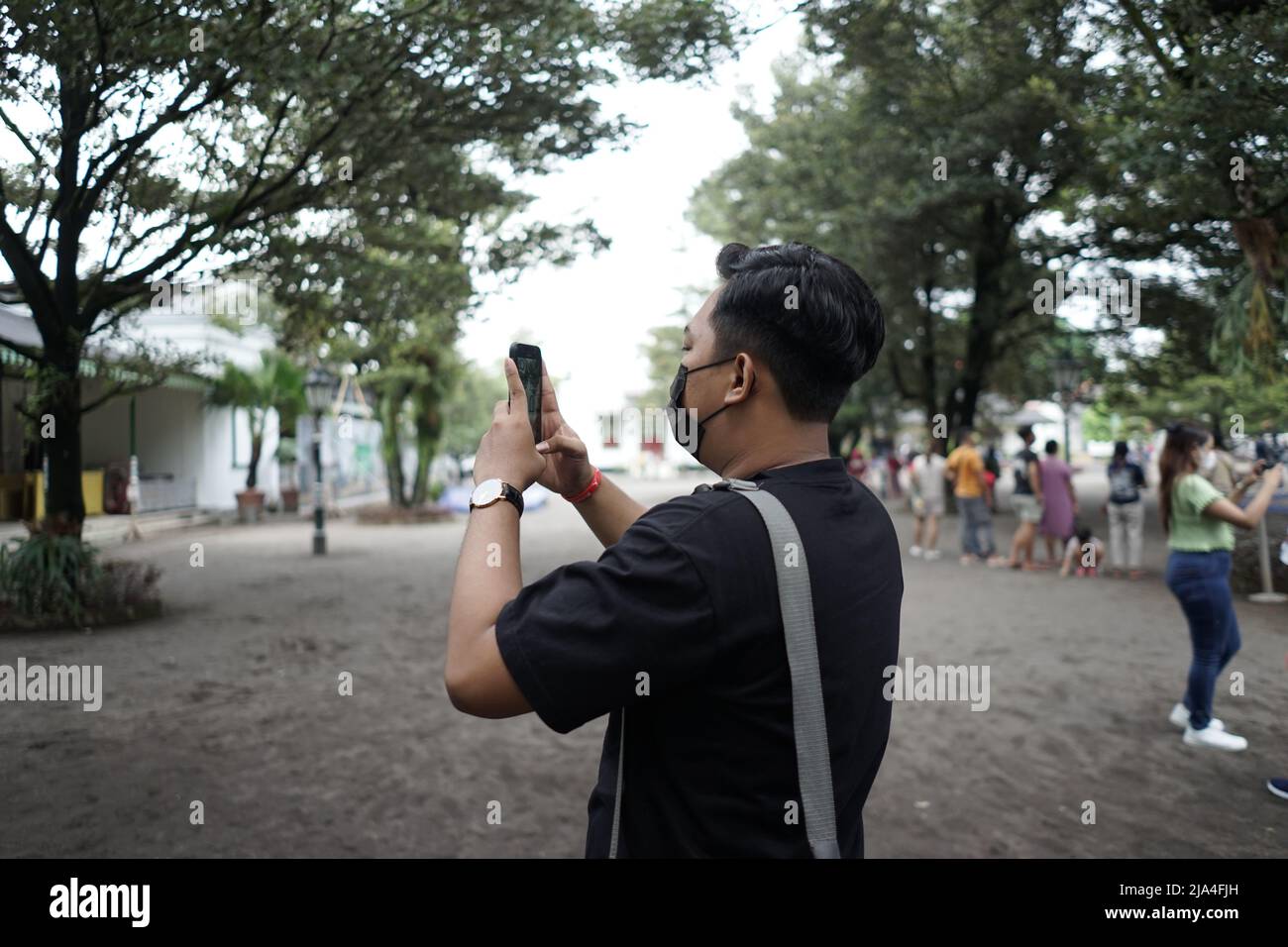 Ein Tourist, der mit seinem Smartphone in Kraton Yogyakarta, Indonesien, Bilder einfängt. Stockfoto