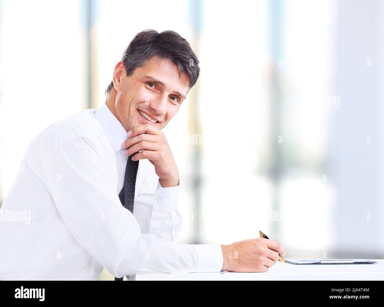 Ein hübscher Geschäftsmann lächelt im Büro Stockfoto
