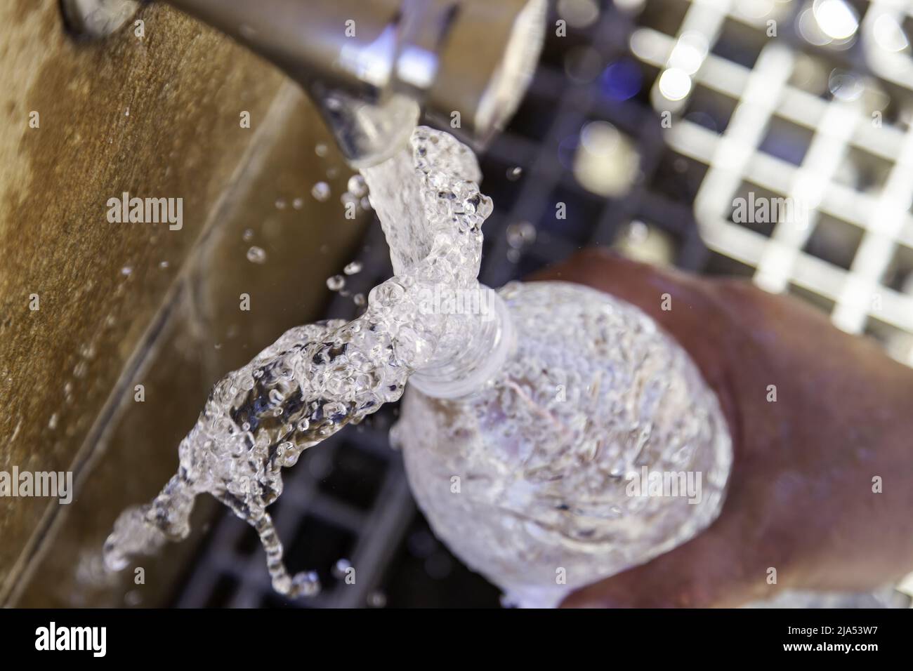 Füllen Wasserflasche in Brunnen, Wasser und Sommer, Erfrischung Stockfoto