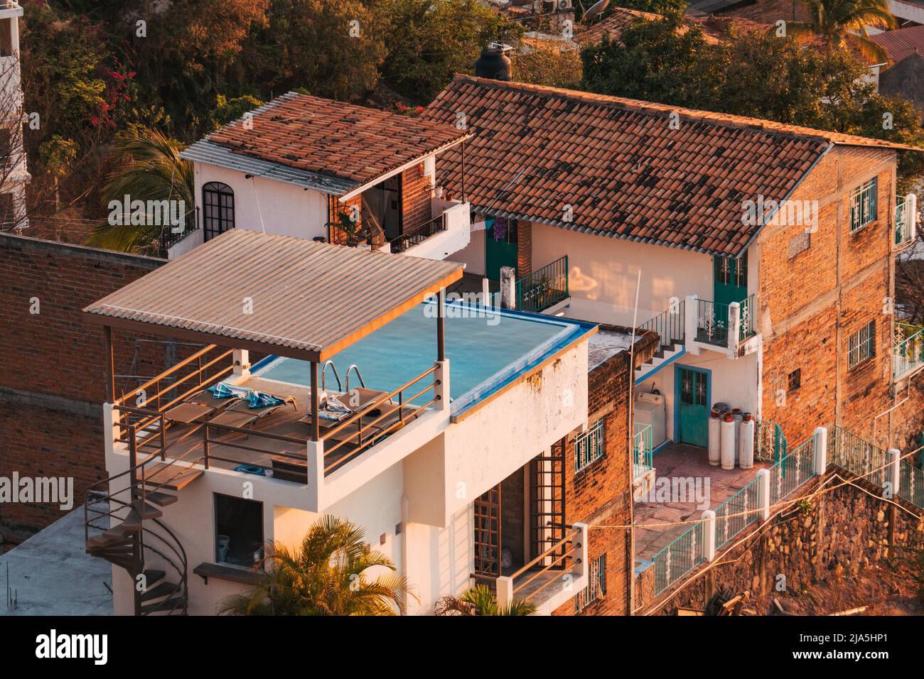 Ein Swimmingpool, der auf einem Backsteinhaus auf einem Hügel in Puerto Vallarta, Mexiko, erbaut wurde Stockfoto