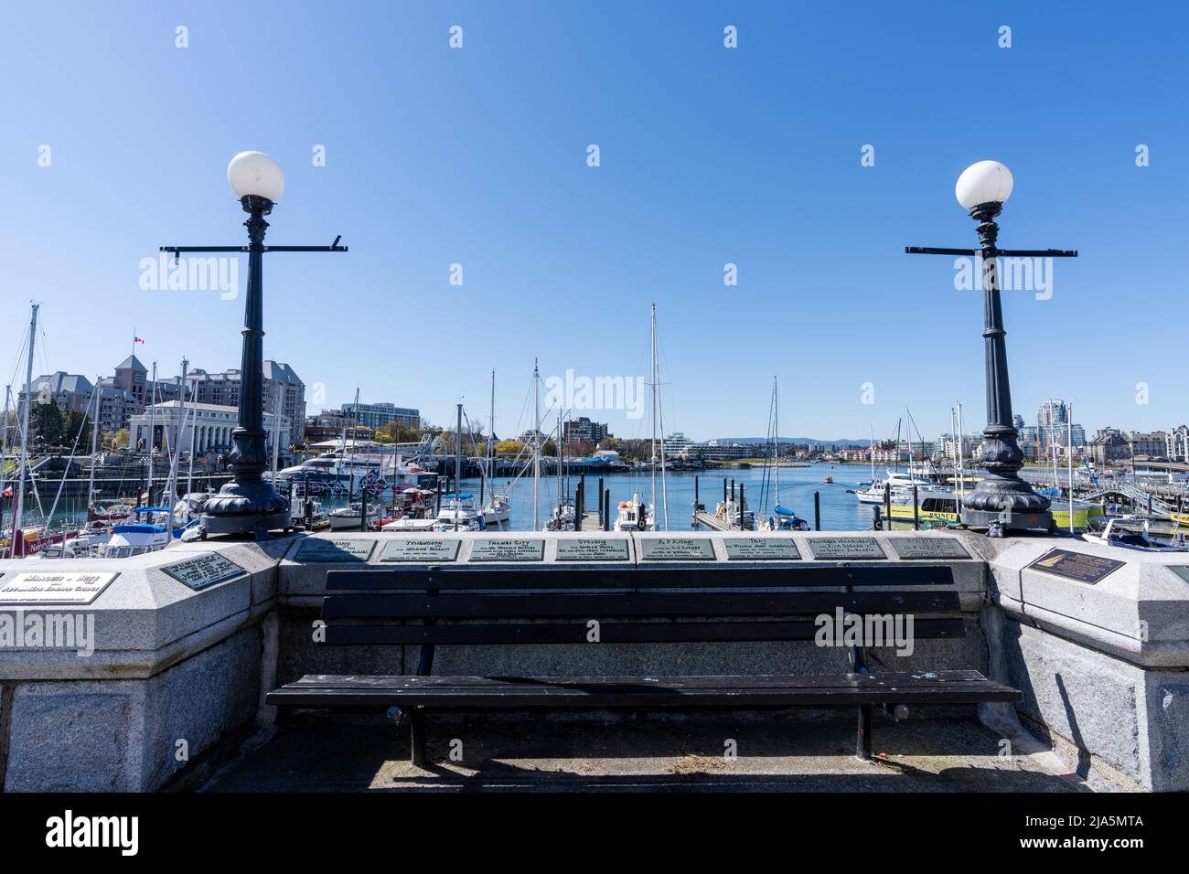 Victoria, BC, Kanada - April 14 2021 : Victoria Innenhafen Damm Marina schwimmt. Historische Gebäude im Hintergrund über blauem Himmel. Stockfoto