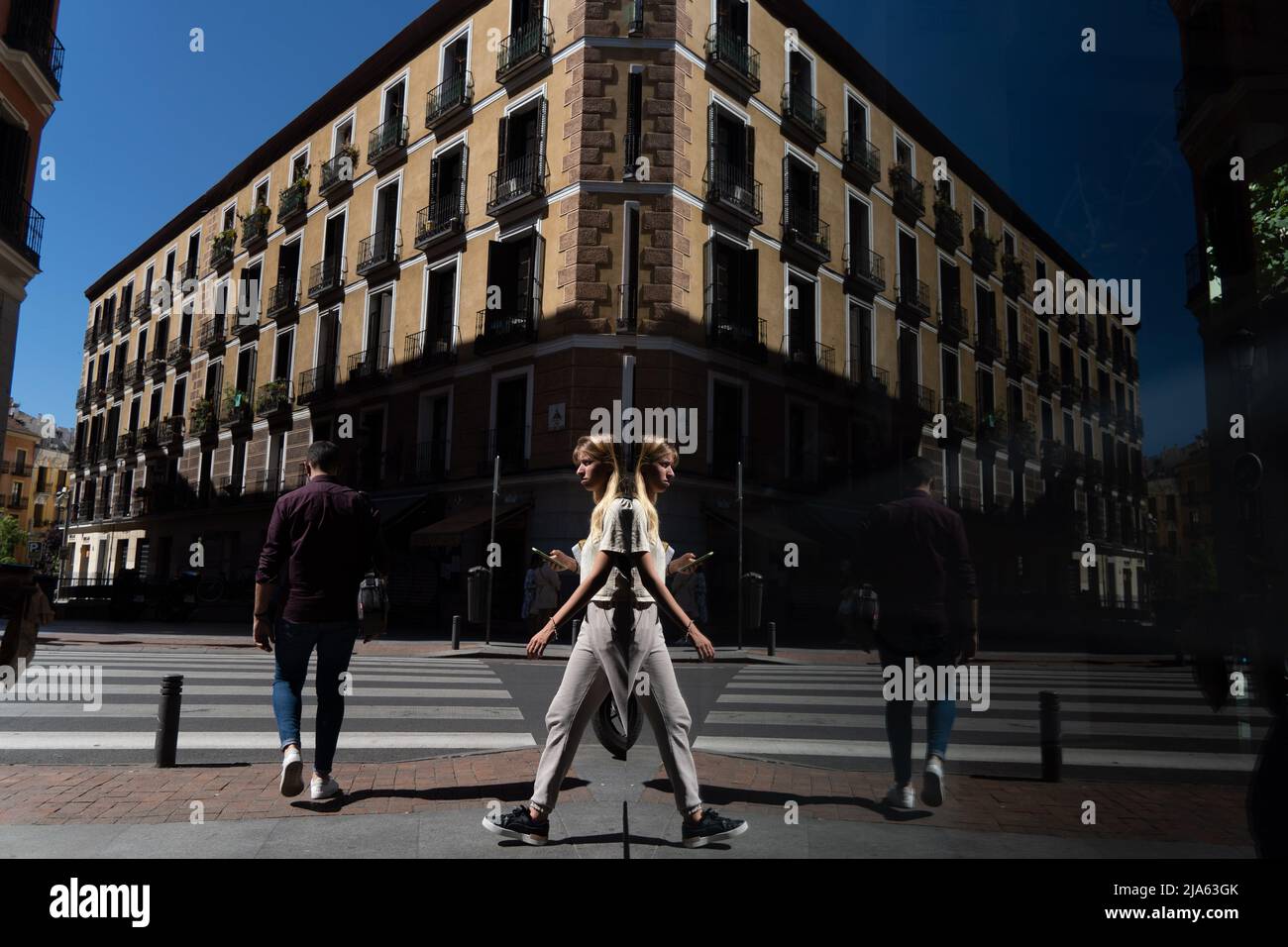 27. Mai 2022, Madrid, Madrid, EspaÃ±A: Eine Frau, die zu Fuß geht, spiegelt sich im Glas eines Geschäfts in Madrid, Spanien. (Bild: © Matias Basualdo/ZUMA Press Wire) Stockfoto