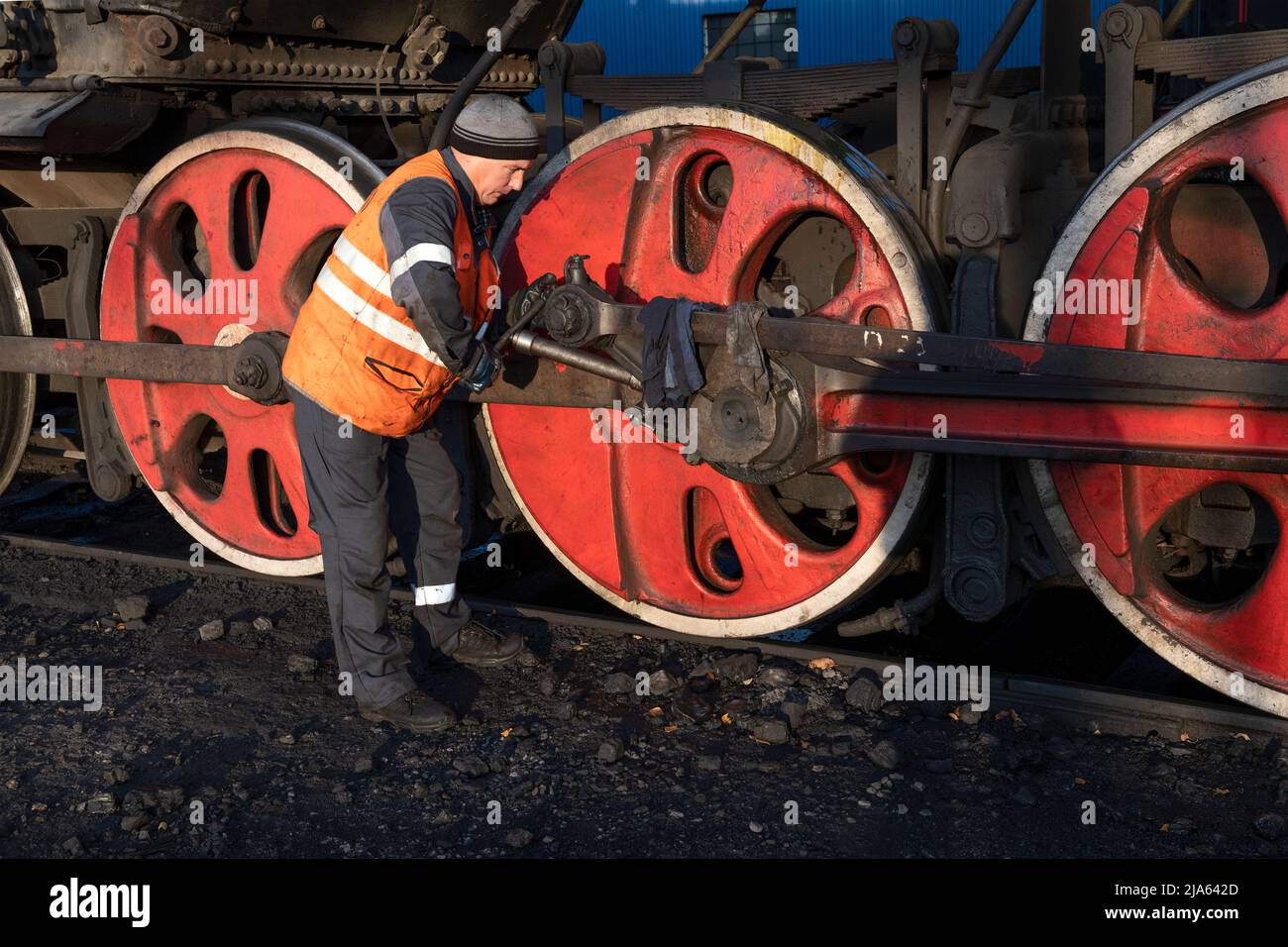 SORTAVALA, RUSSLAND - 07. OKTOBER 2021: Der Lokführer schmiert das Fahrwerk der alten Dampflokomotive. Der Ruskeala Express Stockfoto