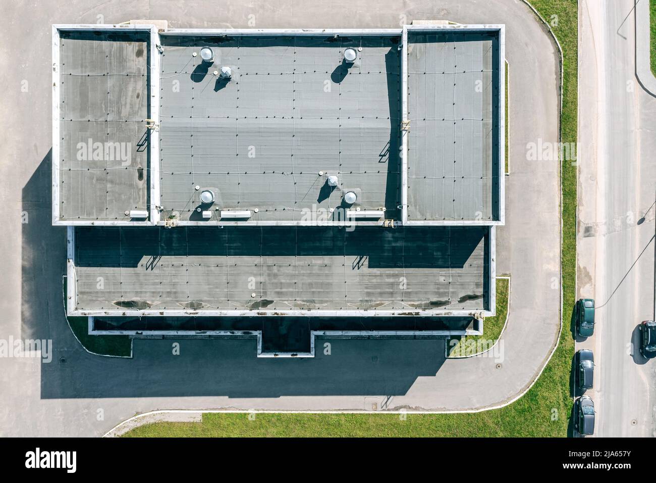 Flaches Schindeldach des Industriegebäudes mit Lüftungssystemen. Luftaufnahme von oben Stockfoto