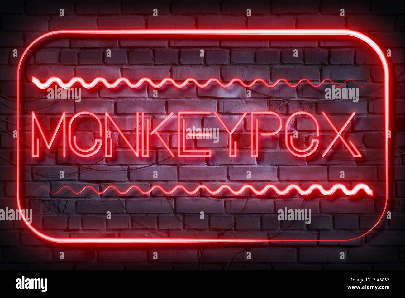 Monkeypox Neon Zeichen auf einer dunklen Ziegelwand Stockfoto