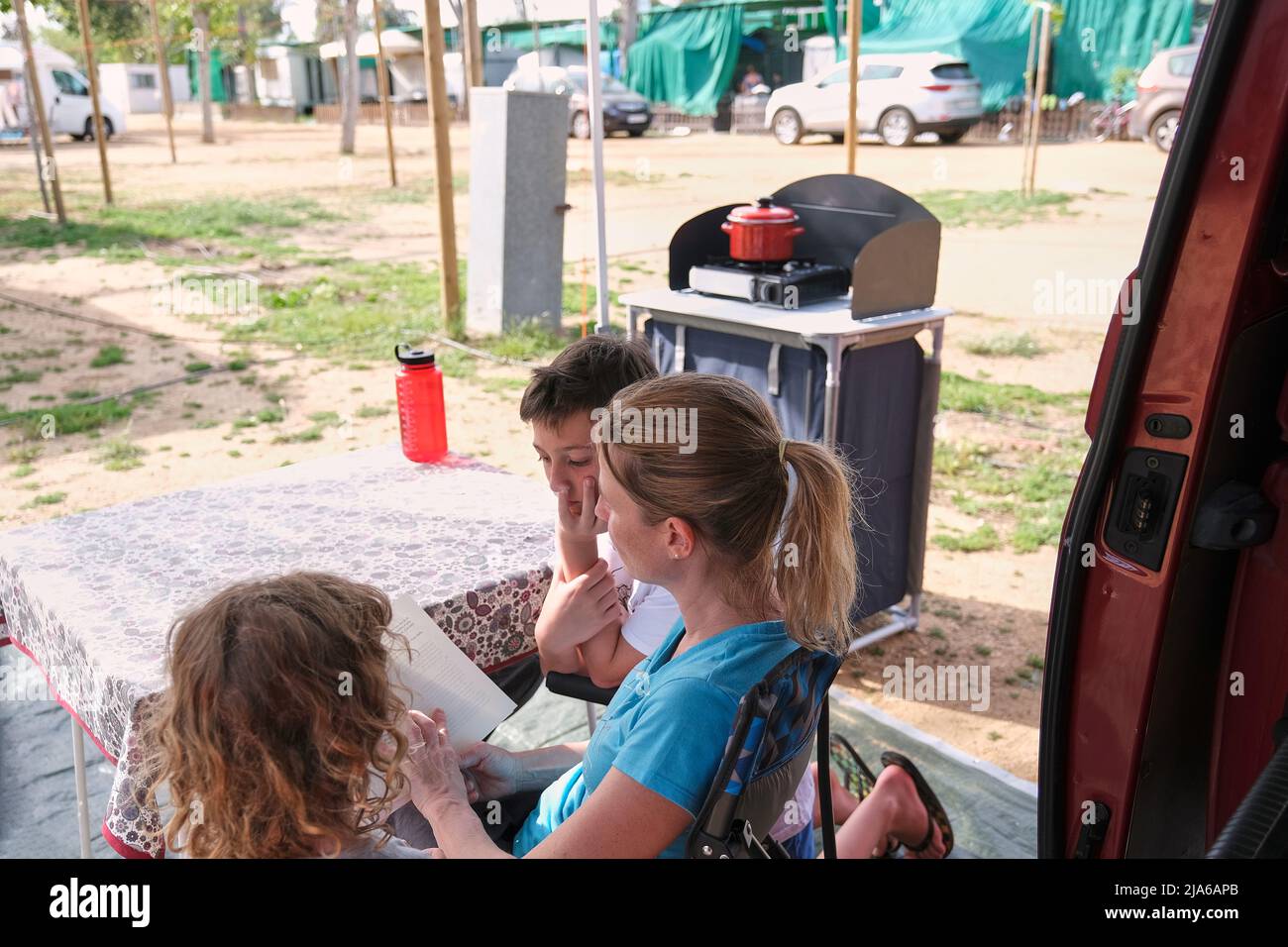 Mutter liest Buch mit Kindern im Urlaub Stockfoto