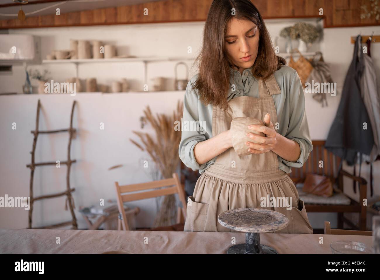 Frau Töpfer arbeitet mit Rohstoffen, kreativen Prozess der Nadelarbeit, die Schaffung handwerklicher Keramik. Keramiker in der Formgebung und Hand beschäftigt Stockfoto