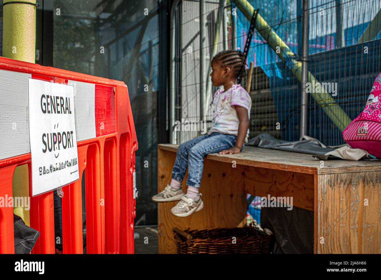 Kind, das vor der Nahrungsmittelbank sitzt, für Familien, die unter finanziellen Schwierigkeiten leiden. Lewisham Donation Hub, London, England. Stockfoto