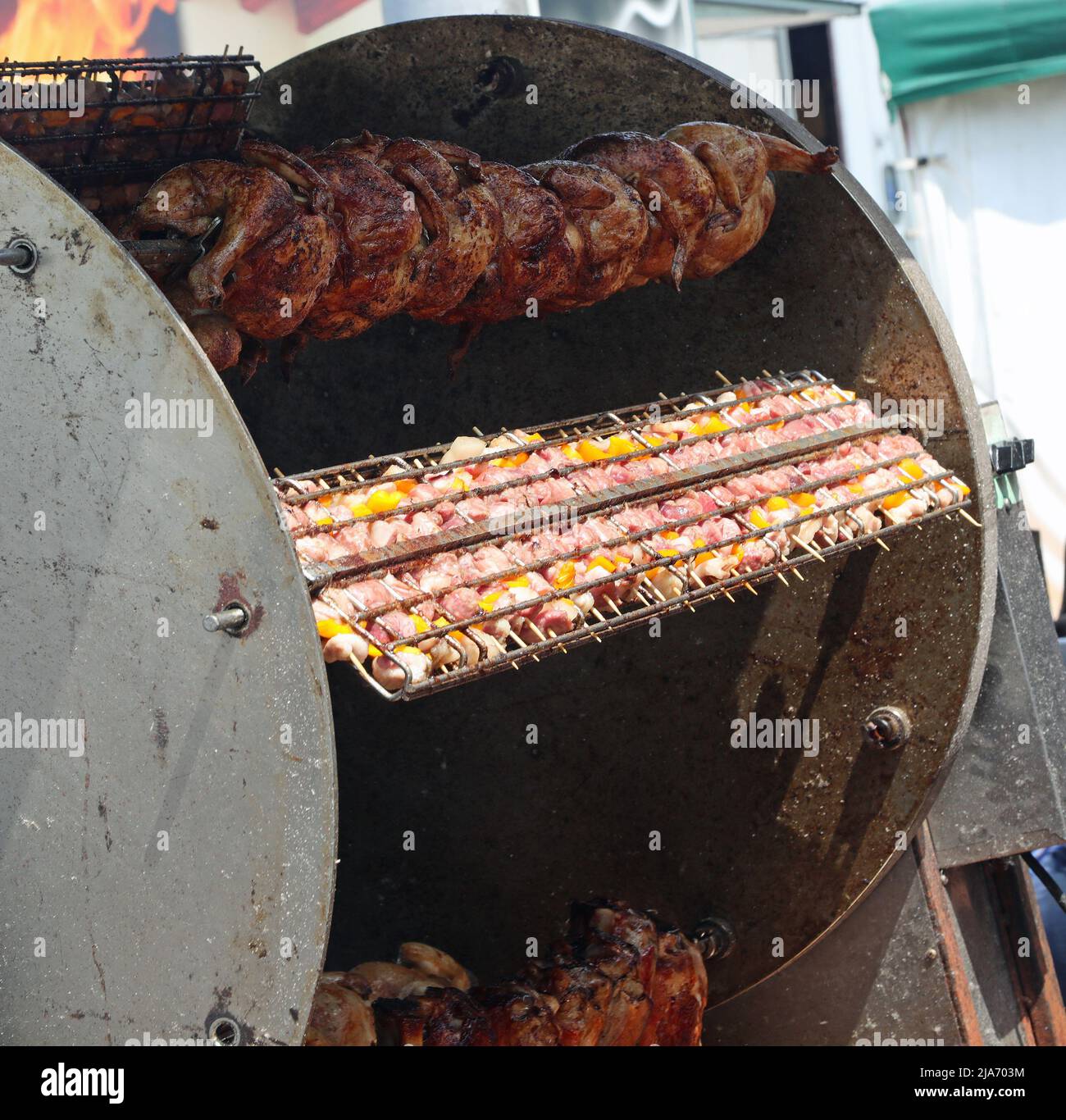 Industrielle Rotisserie mit Spieß-gebratenen Hühnern und Spieße von ...