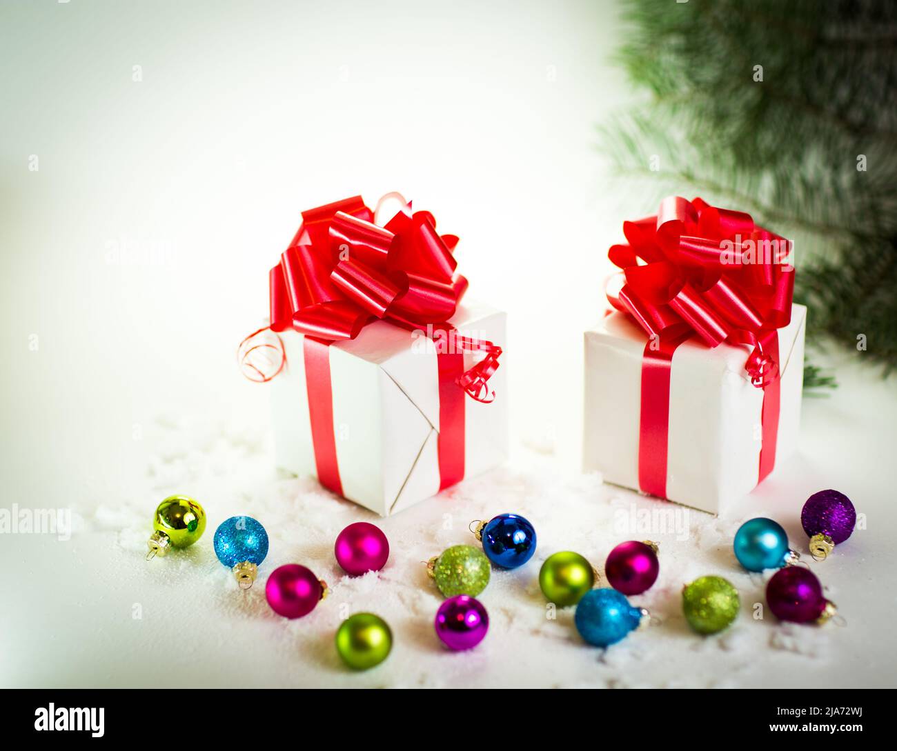 Geschenke auf weißem Hintergrund mit Weihnachtskugeln Stockfoto