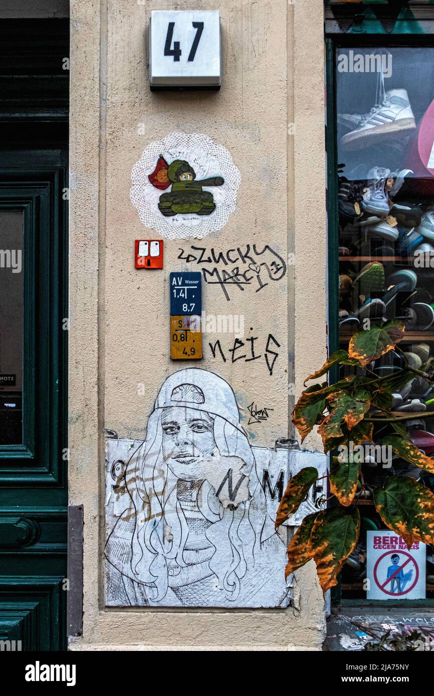 Street Art Paste-ups & Graffiti an der Fassade der Pauls Boutique in der Oderberger Straße, Prenzlauer Berg, Berlin, Deutschland. Stockfoto