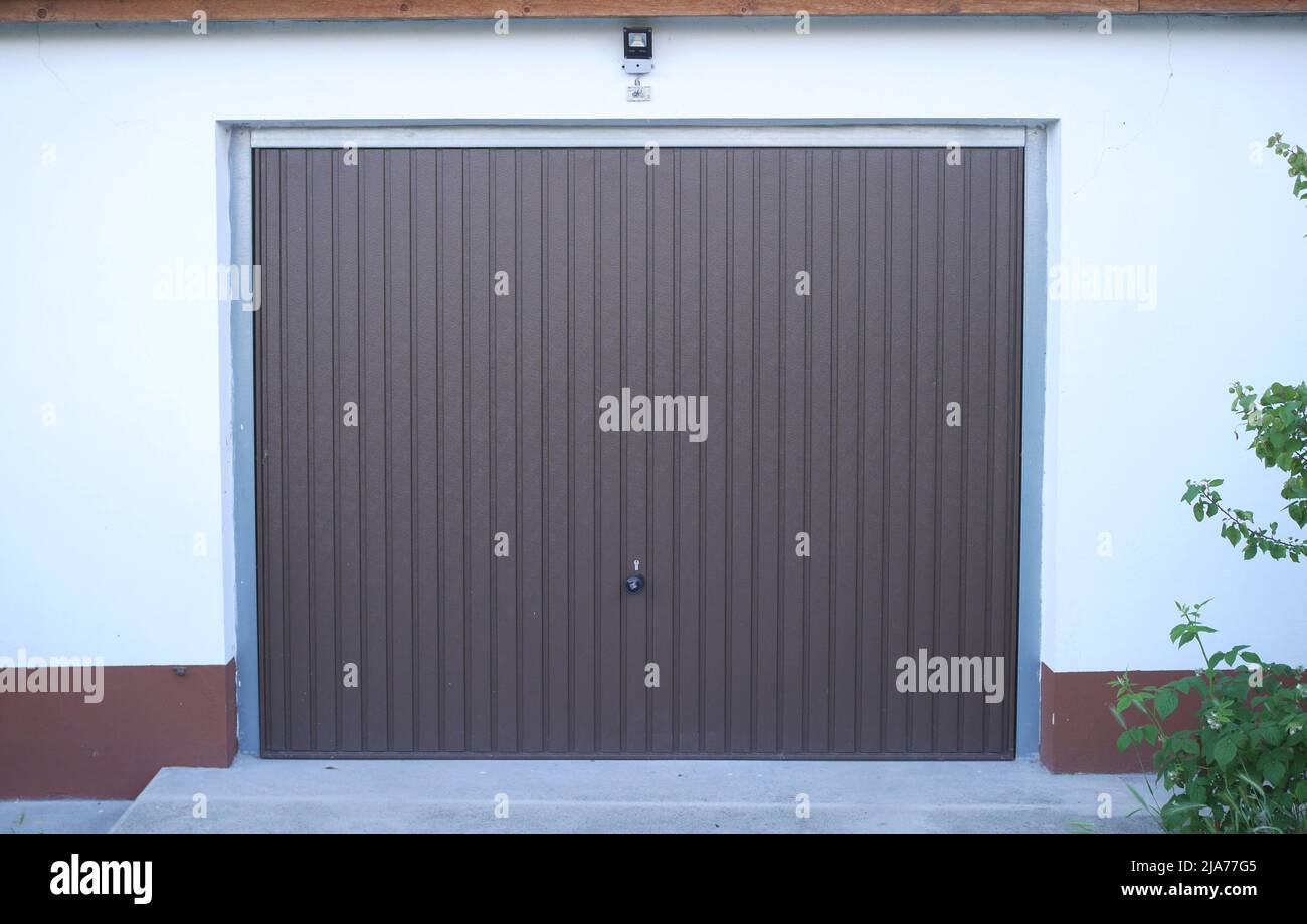 Automatisch betätigtes braunes Garagentor an einem Haus, Ungarn Stockfoto