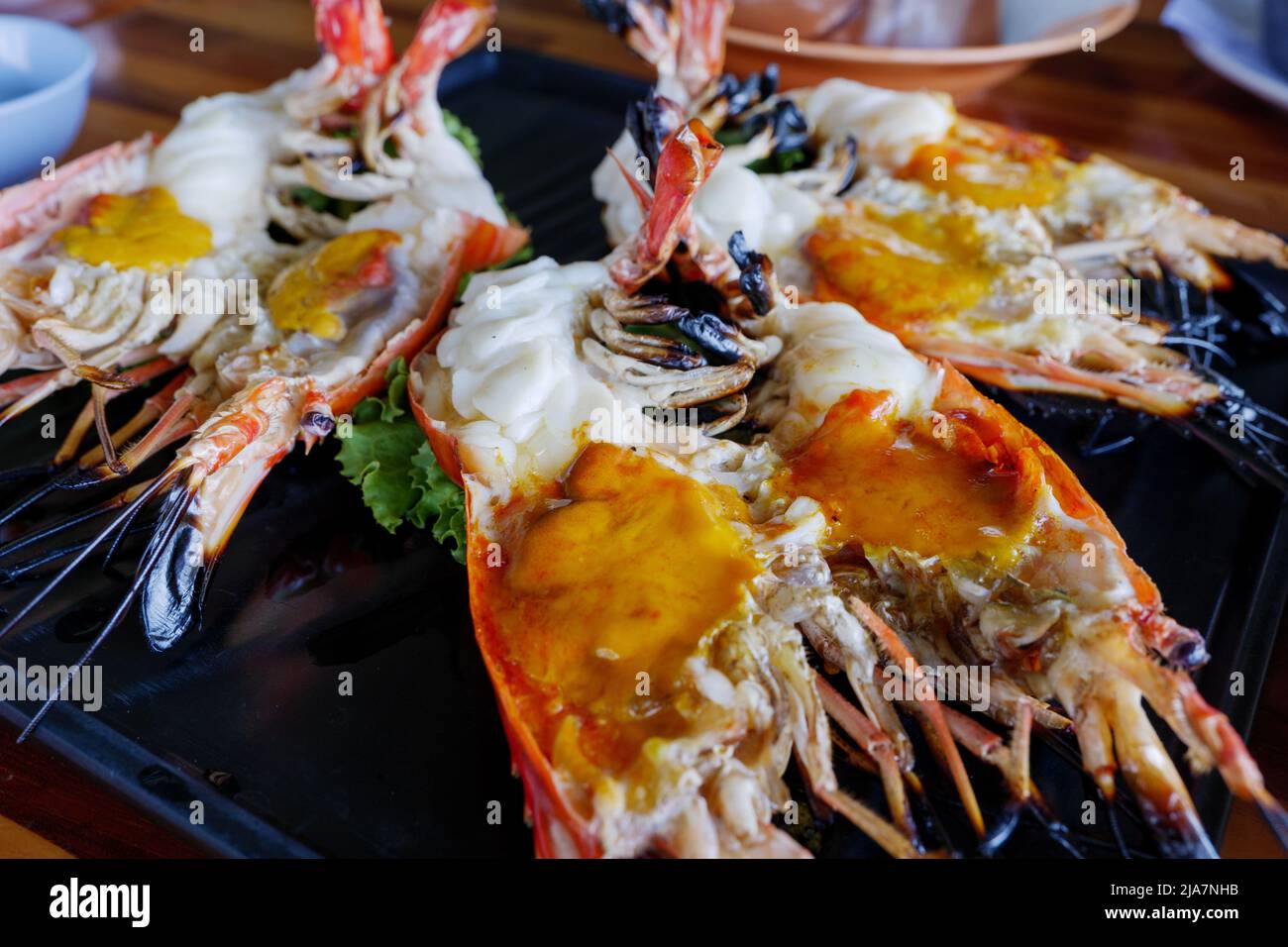 Die Hälfte gegrillten SSwassergarnele, berühmten lokalen Thai Luxus feinen Speisesaal Menü in Thailand, Aufschlag auf einem weißen Teller Teller. Stockfoto
