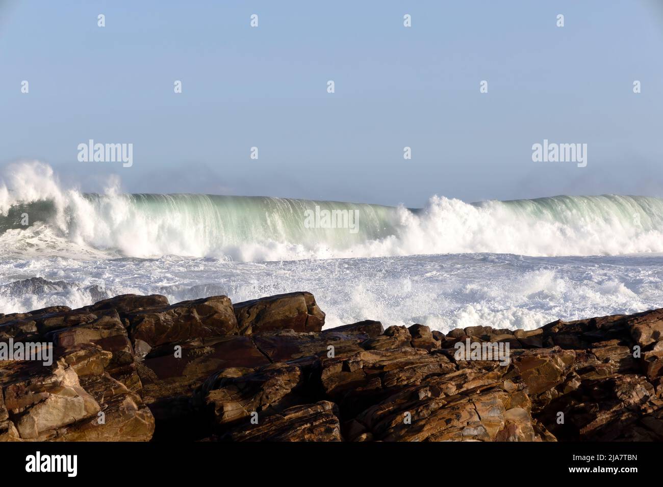 Wellen schlagen auf den Felsen an der Mossel Bay auf der Garden Route von Südafrika Stockfoto