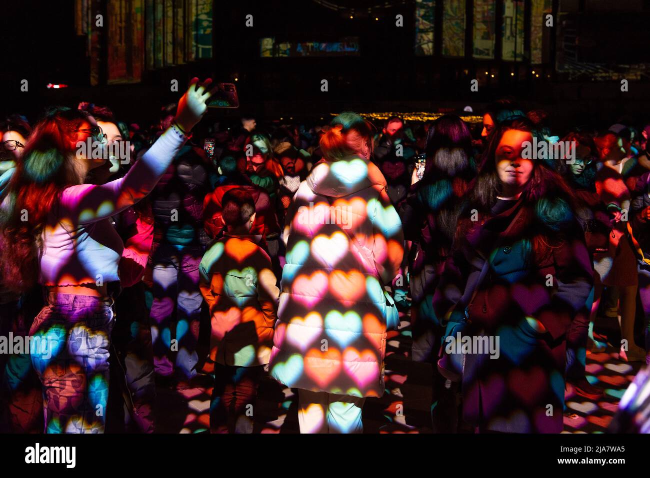 Menschen, die von herzförmigen Projektionen während einer interaktiven Live-Performance auf dem Lunar Festival of Lights, Sofia, Bulgarien, Osteuropa, Balkan, EU Stockfoto