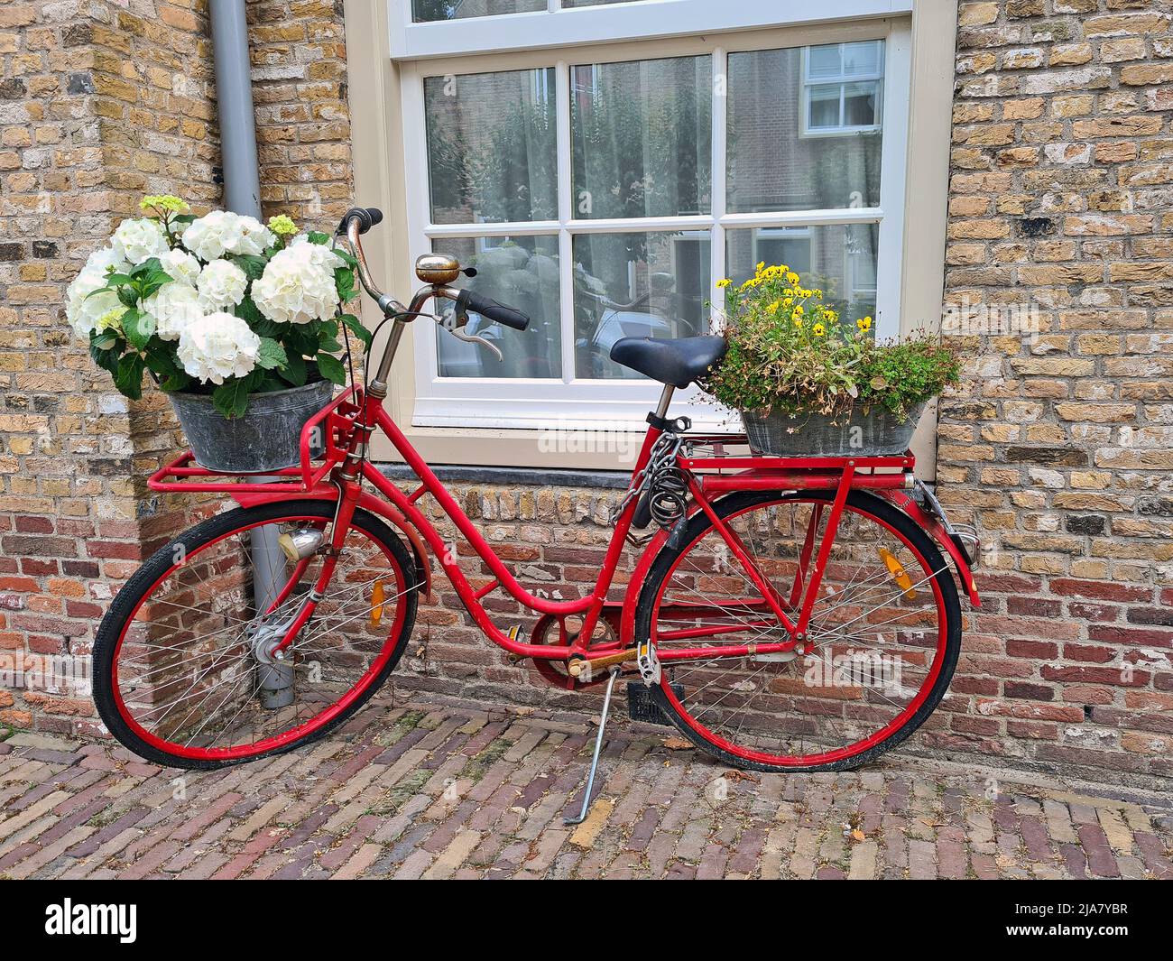 Typisch holländisch: Altes rotes holländisches Fahrrad mit blühenden Blumen in den Niederlanden Stockfoto