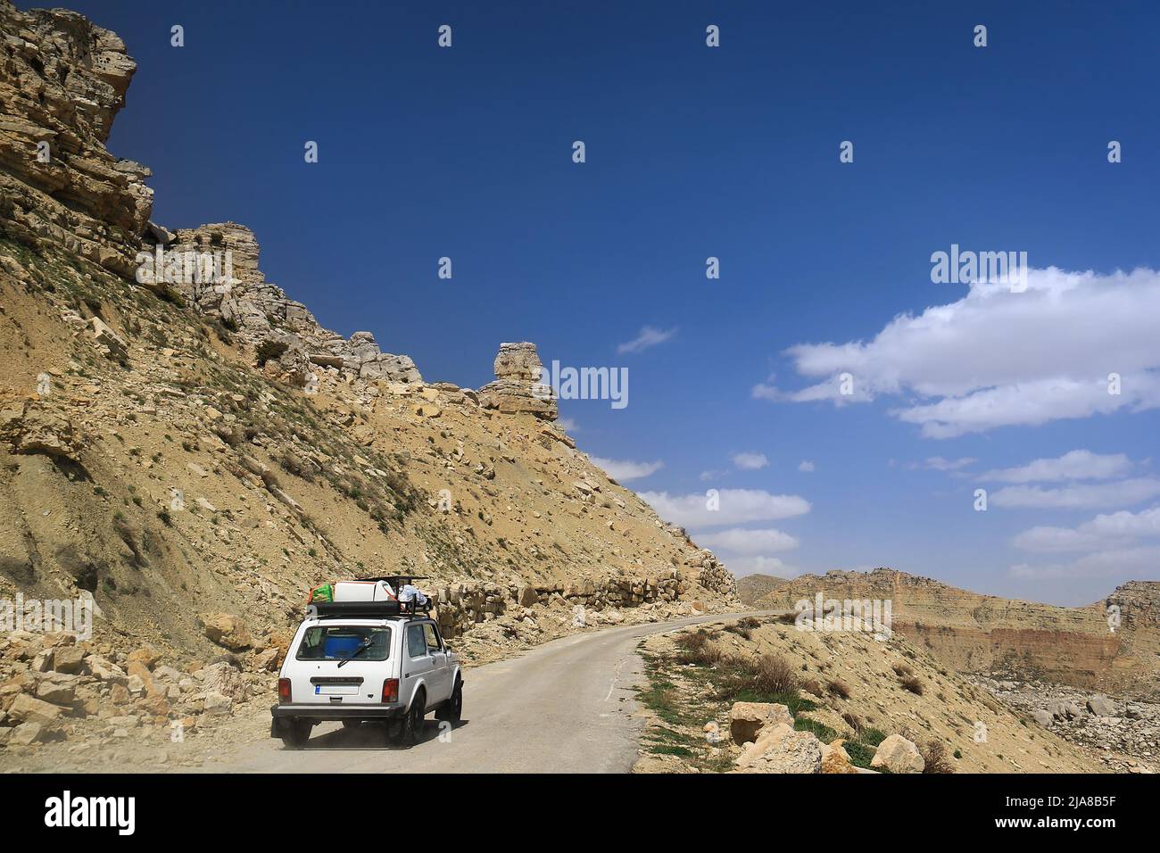 Ein altes Auto, das eine bergige Straße im Libanon hinauf fährt. Stockfoto