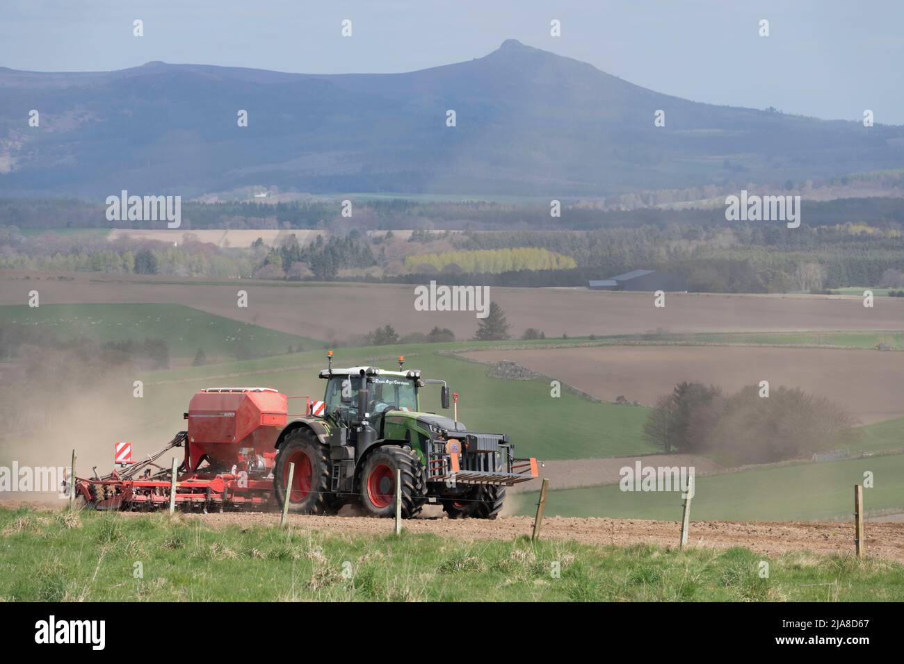Ein landschaftlich reizvoller Blick über die Landschaft von Aberdeenshire in Richtung Bennachie mit einem Fendt-Traktor und Scheibensaatbohrer im Vordergrund Stockfoto