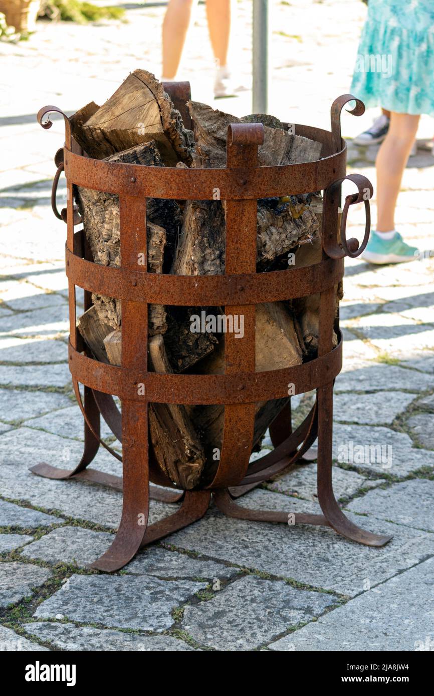 Römischer Metallkamin für öffentliche Räume oder gesellschaftliche Veranstaltungen. Holz für Kamine.Antike Eisenkamine. Stockfoto