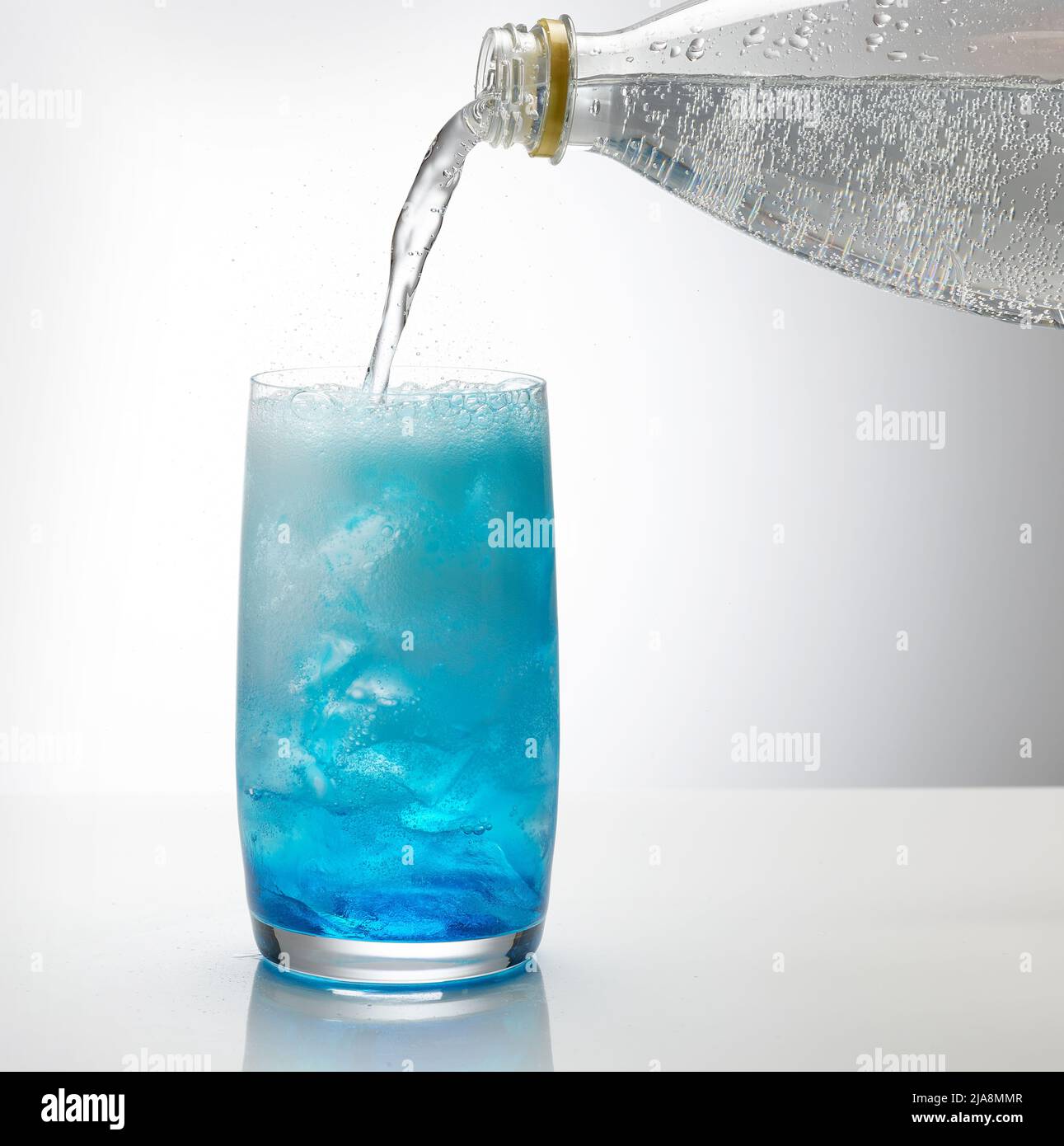 Tonic Gießen in Glas aus Eis und blauem Sirup. Prozess der Herstellung von Cocktail Stockfoto