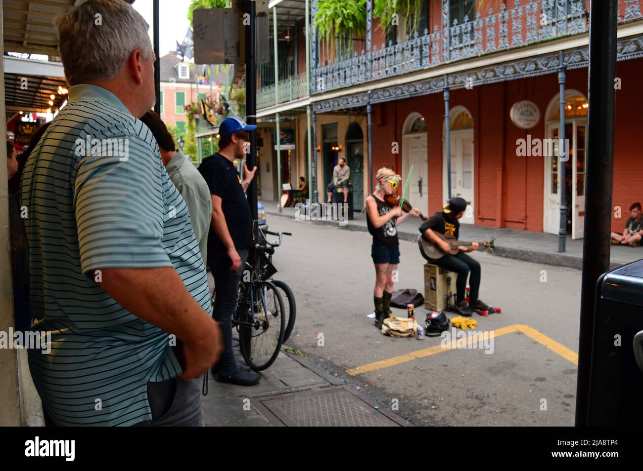 Ein erwachsener Mann sieht einem Musikduo in den Straßen des französischen Viertels von New Orleans zu Stockfoto