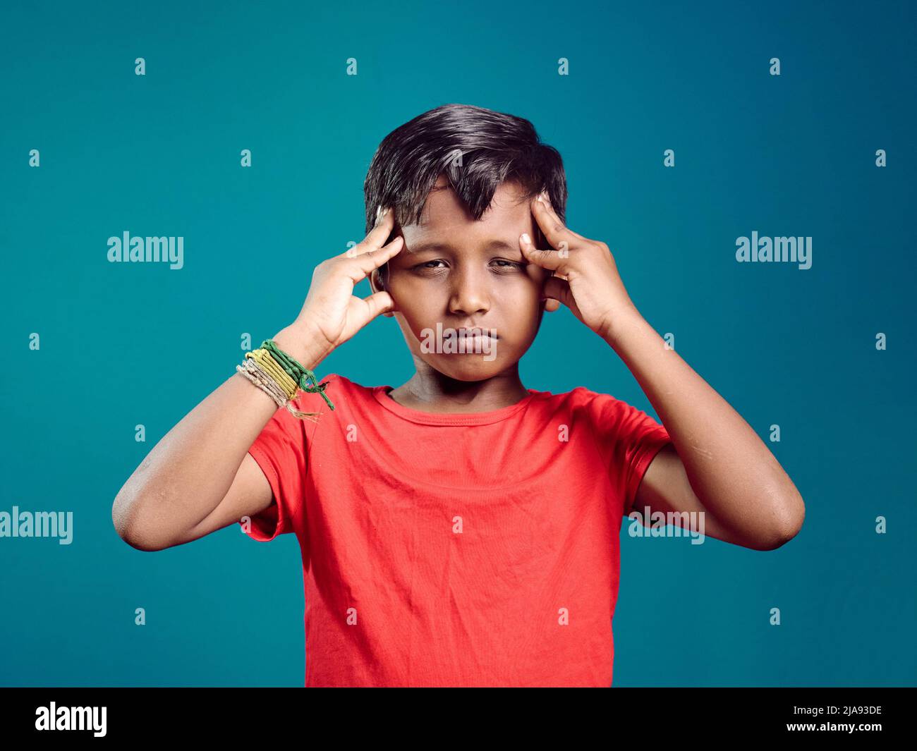 Nahaufnahme Porträt gestresst traurigen asiatischen Jungen mit Hands-on-Tempel, Kopf dreht sich um, negative menschliche Gesichtsausdruck. Asiatische Jungen im Alter von 8 bis 10years Jahren Stockfoto