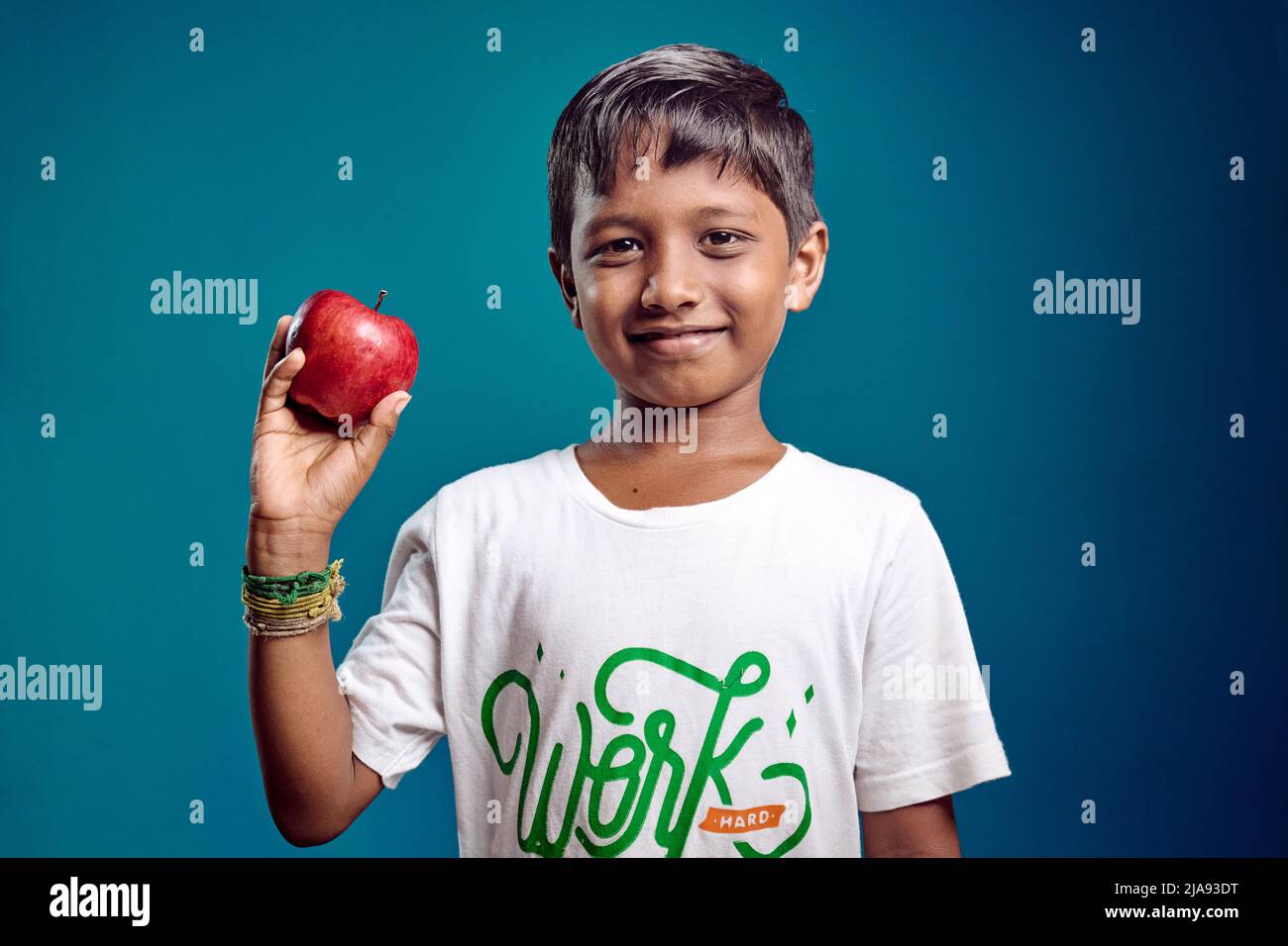 8-10 Jahre alter asiatischer Junge, der mit Apfel posiert. Gesundheit Stockfoto