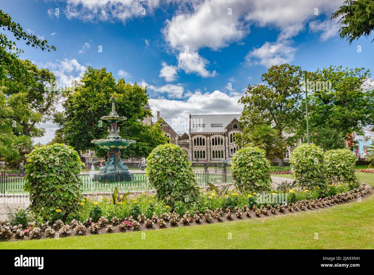 8. Januar 2019: Christchurch, Neuseeland - The Botanical Gardens, with the Pfau Fountain and the Christchurch Arts Centre Buildings. Stockfoto