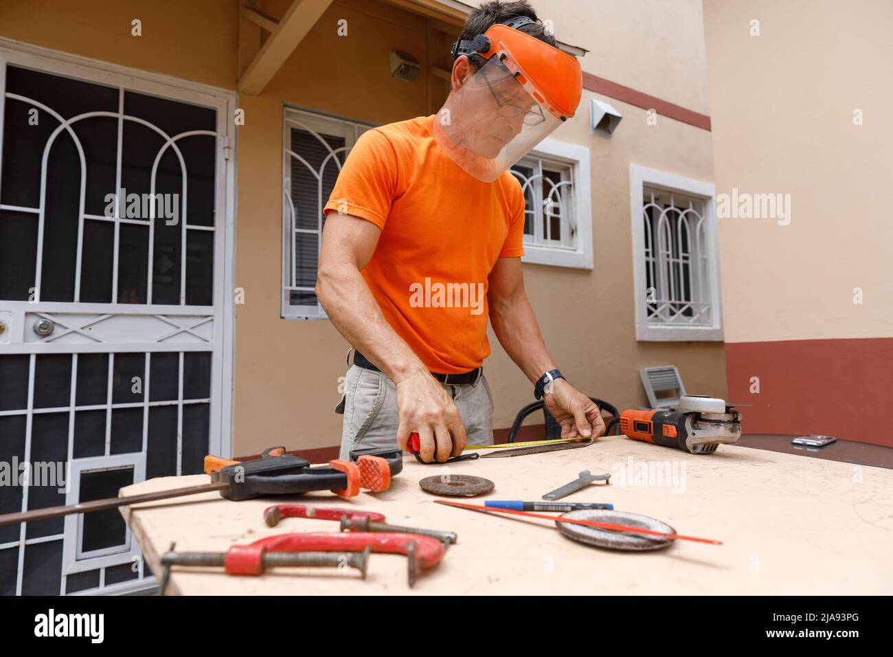 Ein Mann in seinem Hof beschäftigt sich mit Schlosserarbeiten. Hobby, in einer Hauswerkstatt. Stockfoto
