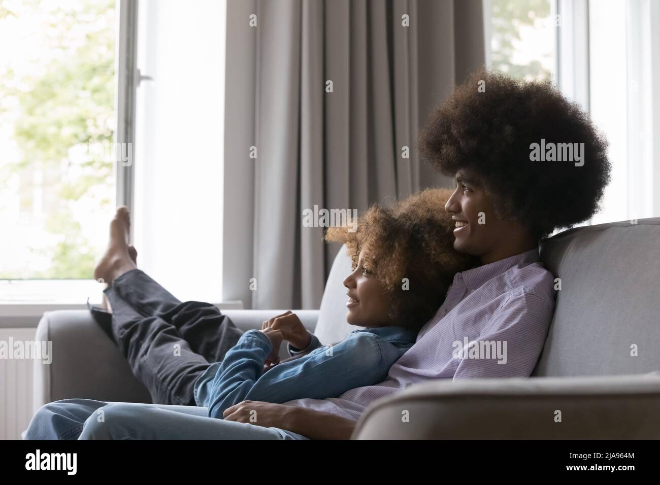 Glücklich verträumt afrikanisch teen Paar in der Liebe ruht auf Couch Stockfoto