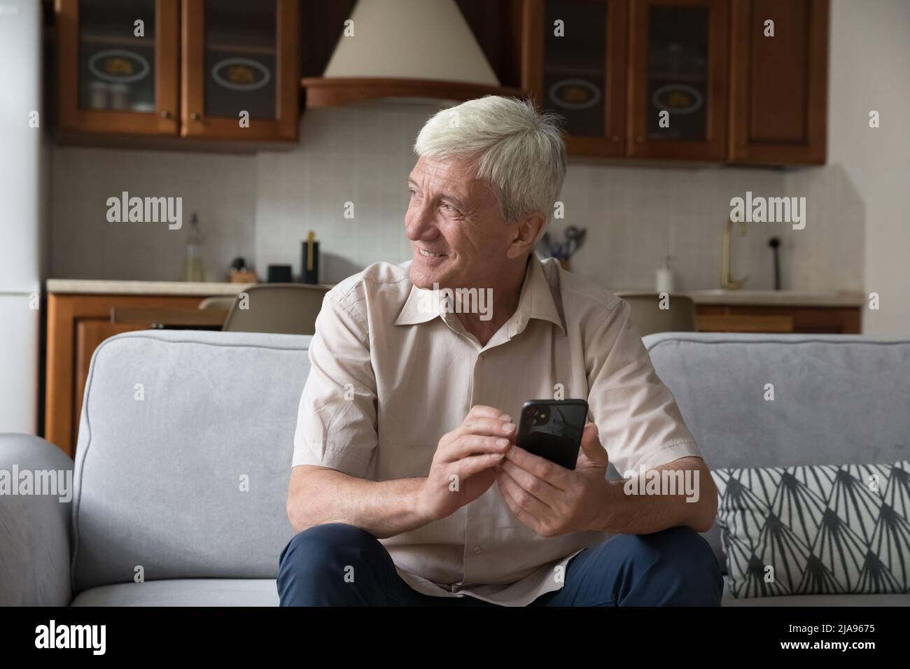 Ältere Männer, die zu Hause bleiben, nutzen das Telefon für die Online-Kommunikation Stockfoto