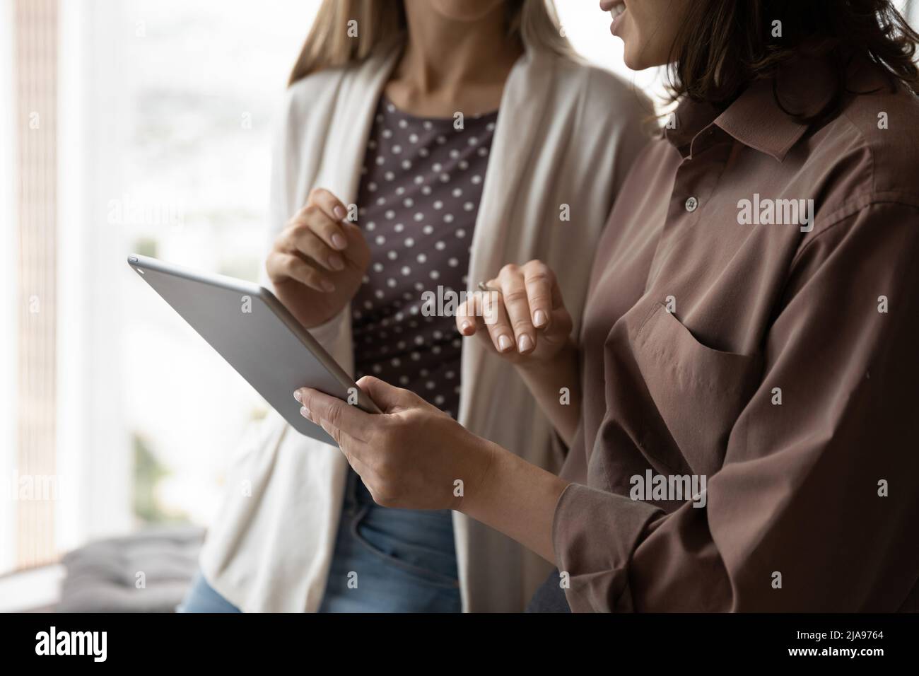 Weibliche Geschäftskollegen, die zusammen ein Tablet nutzen, sehen sich virtuelle Online-Präsentationen an Stockfoto
