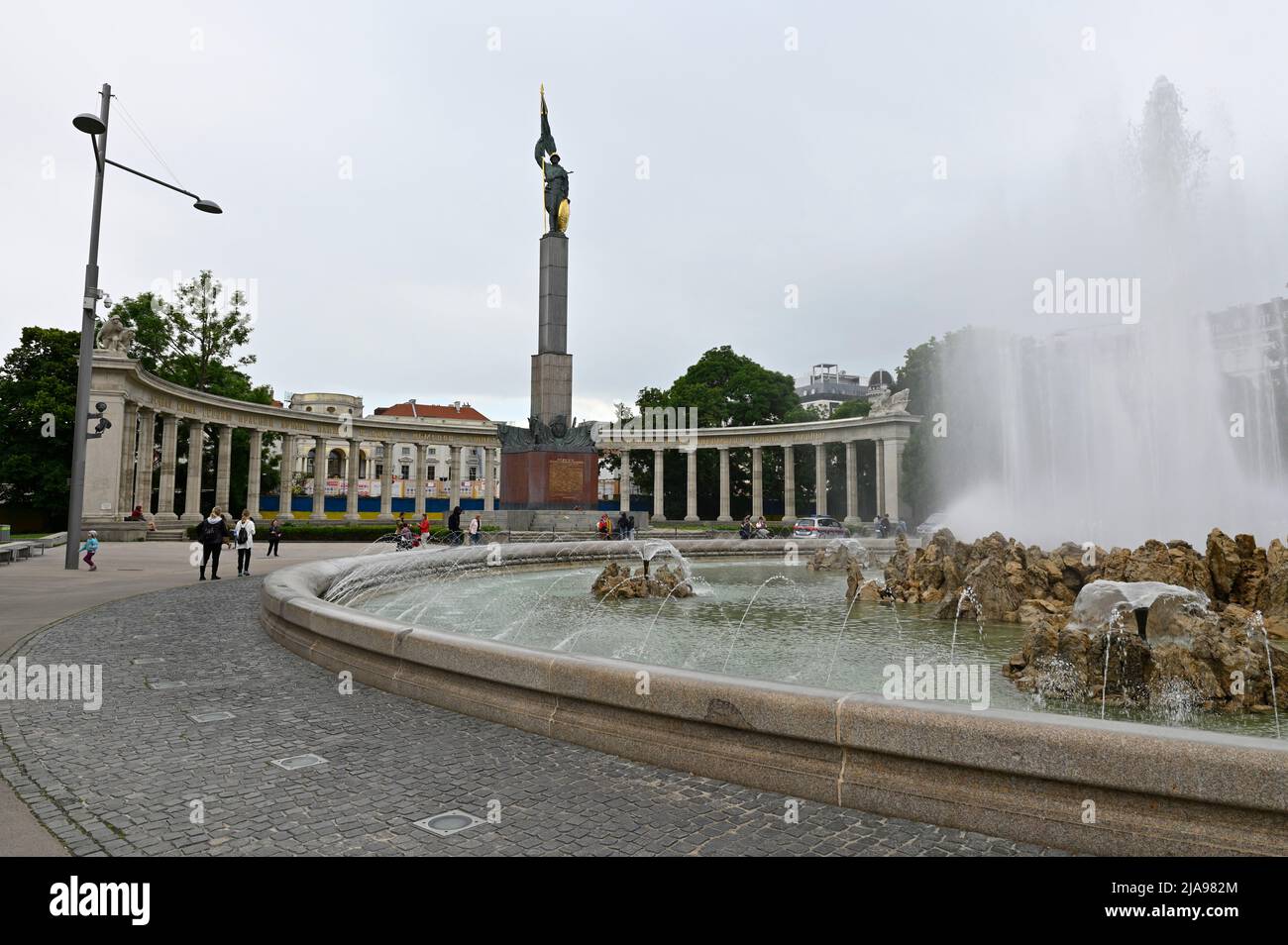 Wien, Österreich. Heldendenkmal am Schwarzenbergplatz mit der „Backsteinwand“ im Hintergrund in den ukrainischen Nationalfarben Blau und Gelb Stockfoto