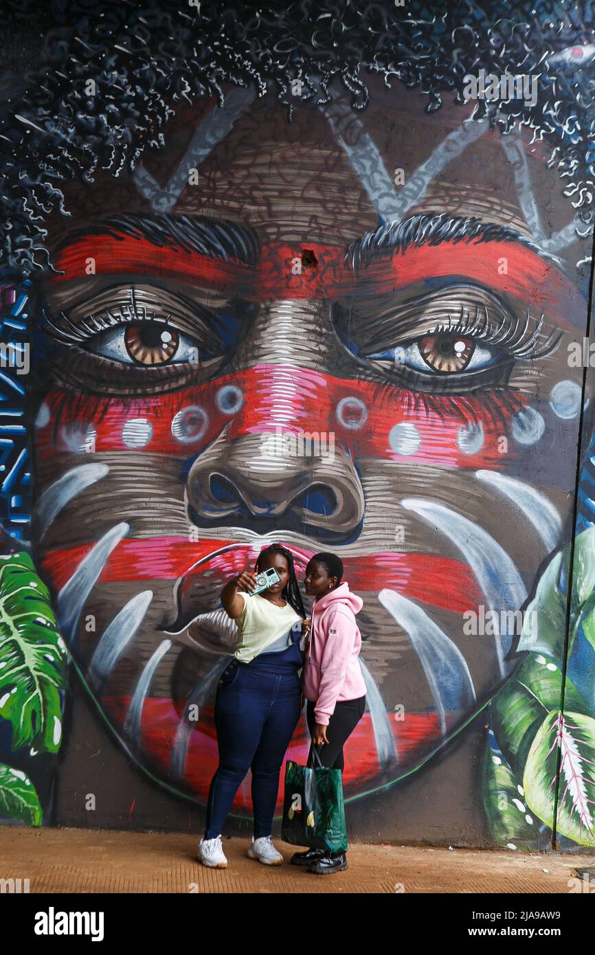 Nairobi, Kenia. 28.. Mai 2022. Zwei kenianische Frauen machen Selfies neben den Wandmalereien, die auf der Kenya Defense Forces Air Show im Uhuru Gardens National Monument and Museum ausgestellt sind. Die kostenlose Air Show war ein Vorläufer der Inbetriebnahme des Uhuru Gardens National Monument and Museum. Es wurde von der Kenya Air Force geleitet und umfasste die kenianischen Wildlife Services sowie zivile Aerobatic- und Sky Diving-Teams. Ziel war es, die Öffentlichkeit zu unterhalten und zu erziehen. Kredit: SOPA Images Limited/Alamy Live Nachrichten Stockfoto