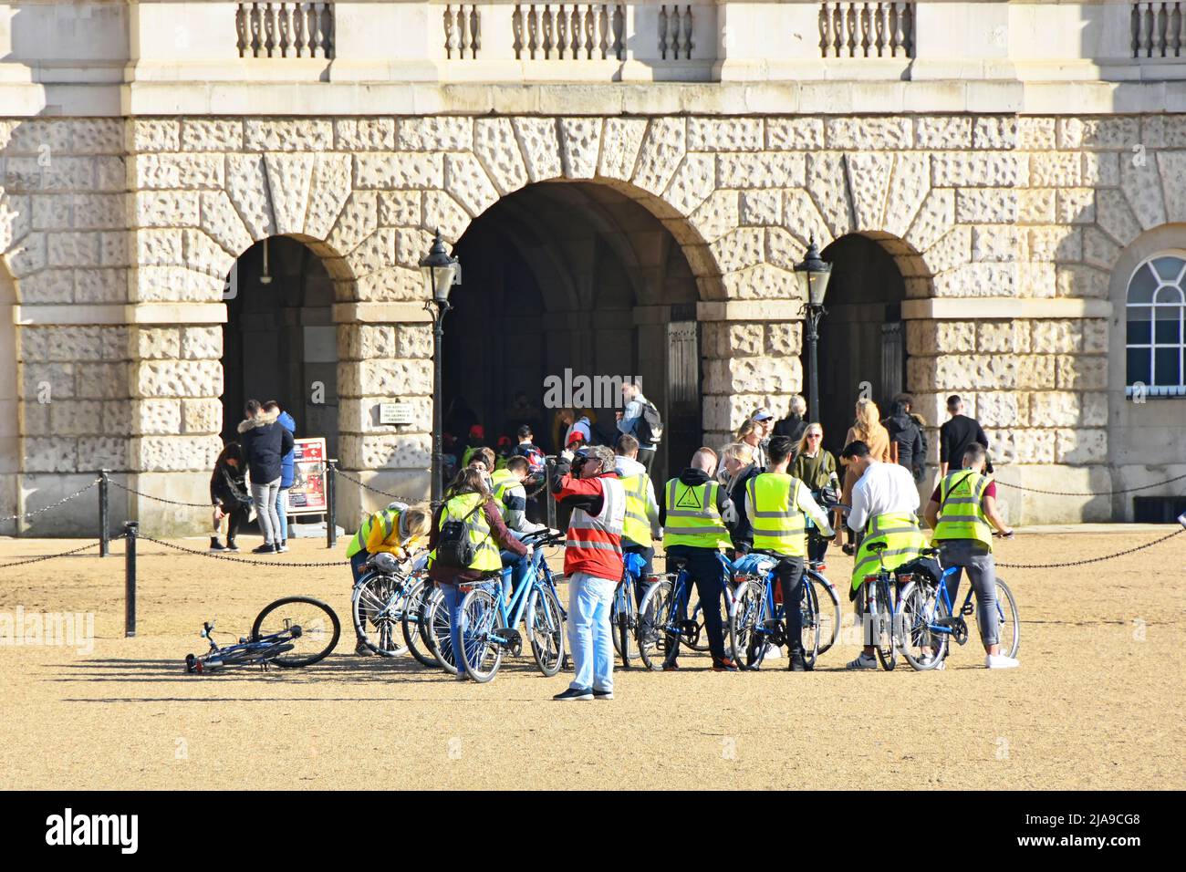 Eine Gruppe von Touristen, die auf einer Fahrradtour mit gut sichtbaren Jacken auf dem historischen Horse Guards Parade Ground für einen Fotostopp in London England, Großbritannien, unterwegs sind Stockfoto