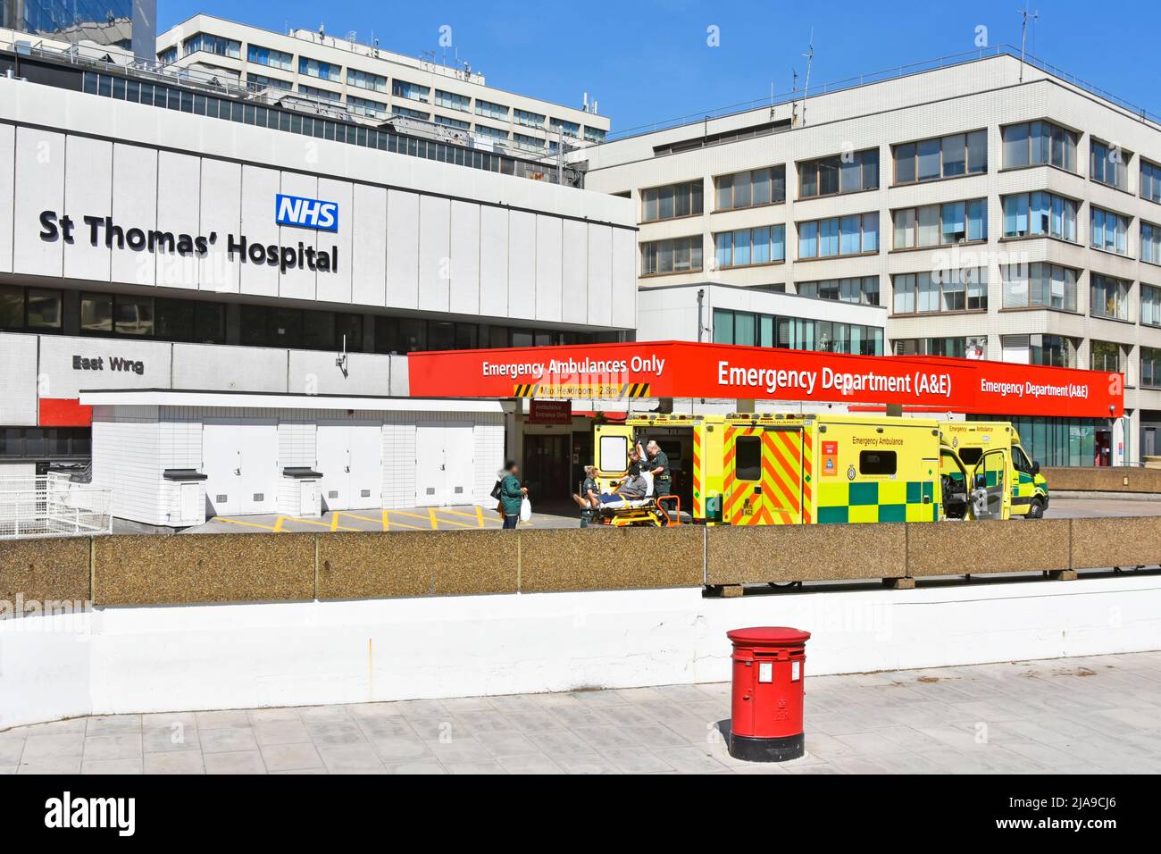 London Rettungswagen Sanitäter sorgen für Bahre Patienten Lieferung an A&E Unfall healthcare Abteilung Gebäude an der NHS-Krankenhaus Lambeth UK Stockfoto