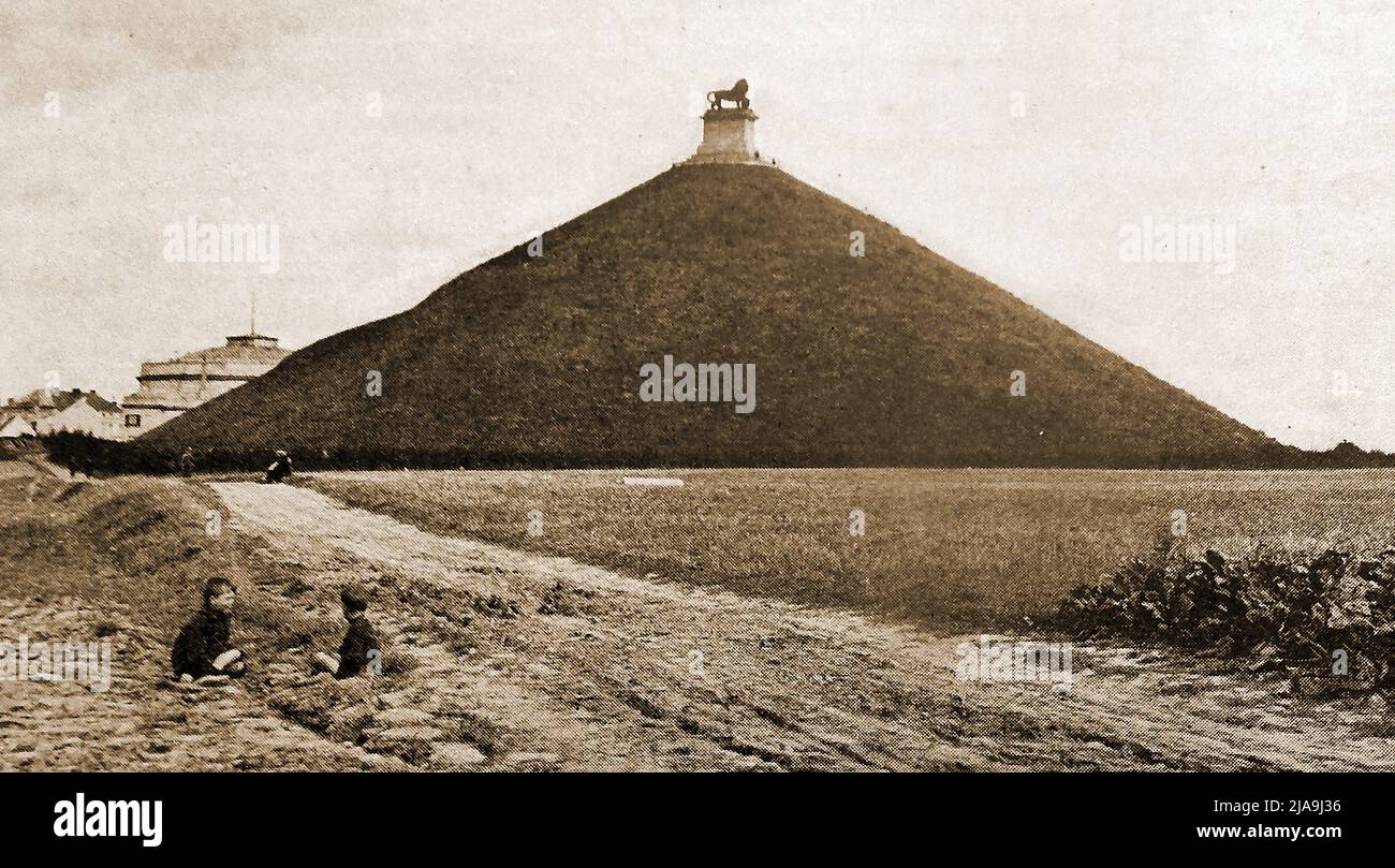 Ein Blick auf den Löwenberg aus den 1930er Jahren (auch bekannt als Butte du Lion; Löwenhügel/Knoll; Niederländisch: Leeuw van Waterloo; Löwe von Waterloo, gelegen am Schauplatz der Schlacht von Waterloo mit zwei einheimischen Kindern, die in der Nähe ein Picknick machen ---- Een uitzicht uit 1930 op Lion's Mount (ook bekend als Butte du Lion; Lion's Hillock/Knoll; gelegen op de plaats van de Slag bij Waterloo met twee lokale kinderen die picknicken in de buurt -- - Une vue des années 1930 du Mont du Lion (également connu sous le nom de Butte du Lion; Lion’s Hillock/Knoll; situé sur les lieux de la bataille de Waterloo. (Ingenieur Jean- Stockfoto