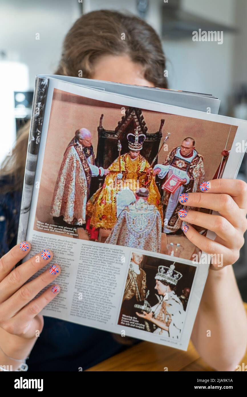 Fächer mit Fingernägeln, die mit der britischen Flagge bemalt sind und eine Kopie des Magazins OK mit einem Bild der Krönung der Königin halten. Platinum Jubilee Juni 2022 Stockfoto