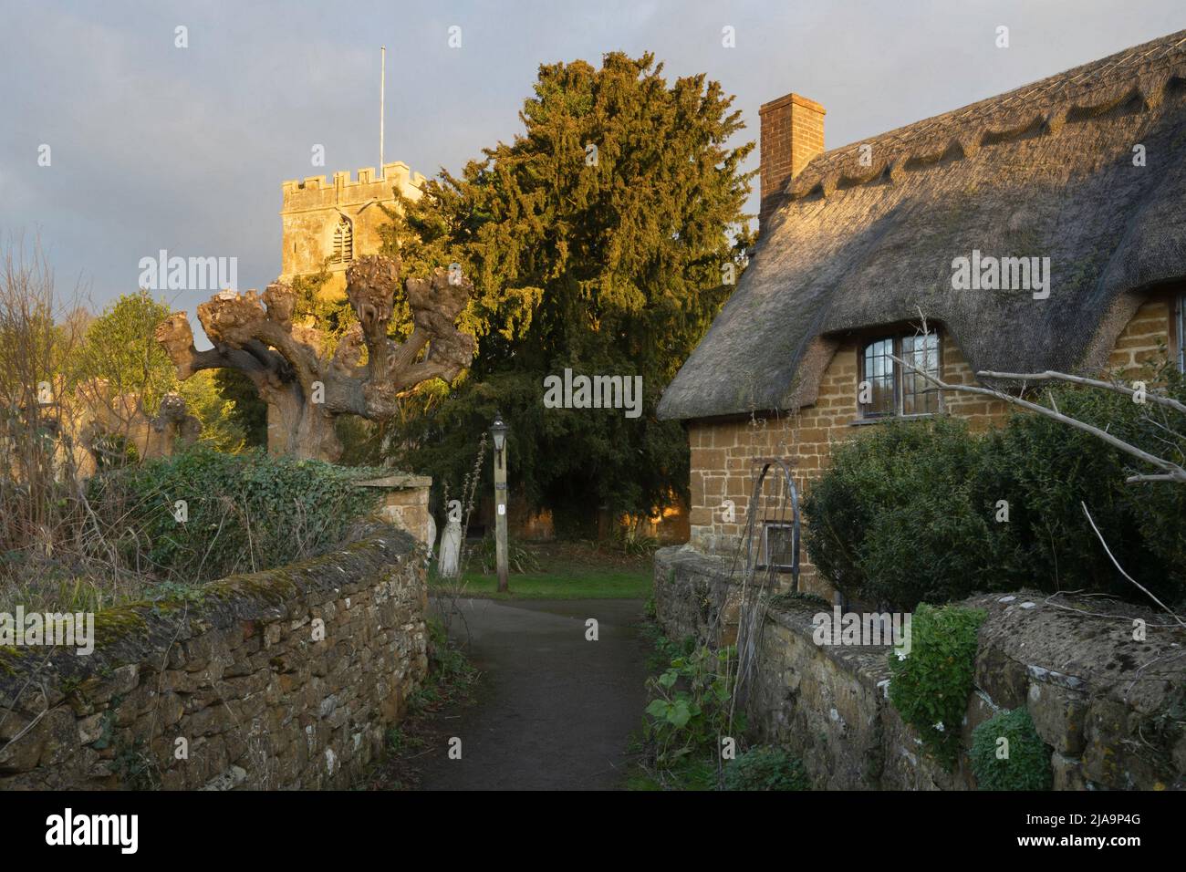 Ferienhaus und Kirche in Ilmington, Cotswolds, Warwickshire, England. Stockfoto