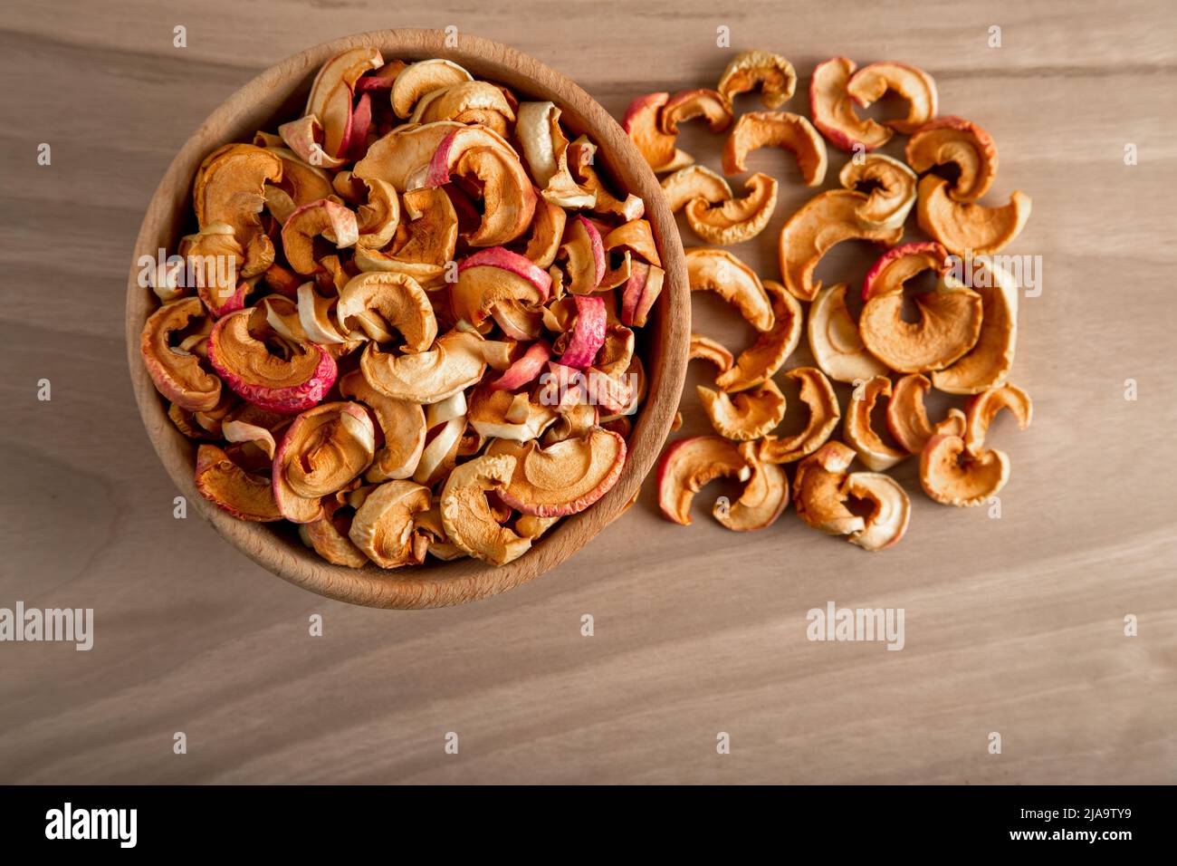 Schüssel voller getrockneter Äpfel auf einem hölzernen Hintergrund Stockfoto
