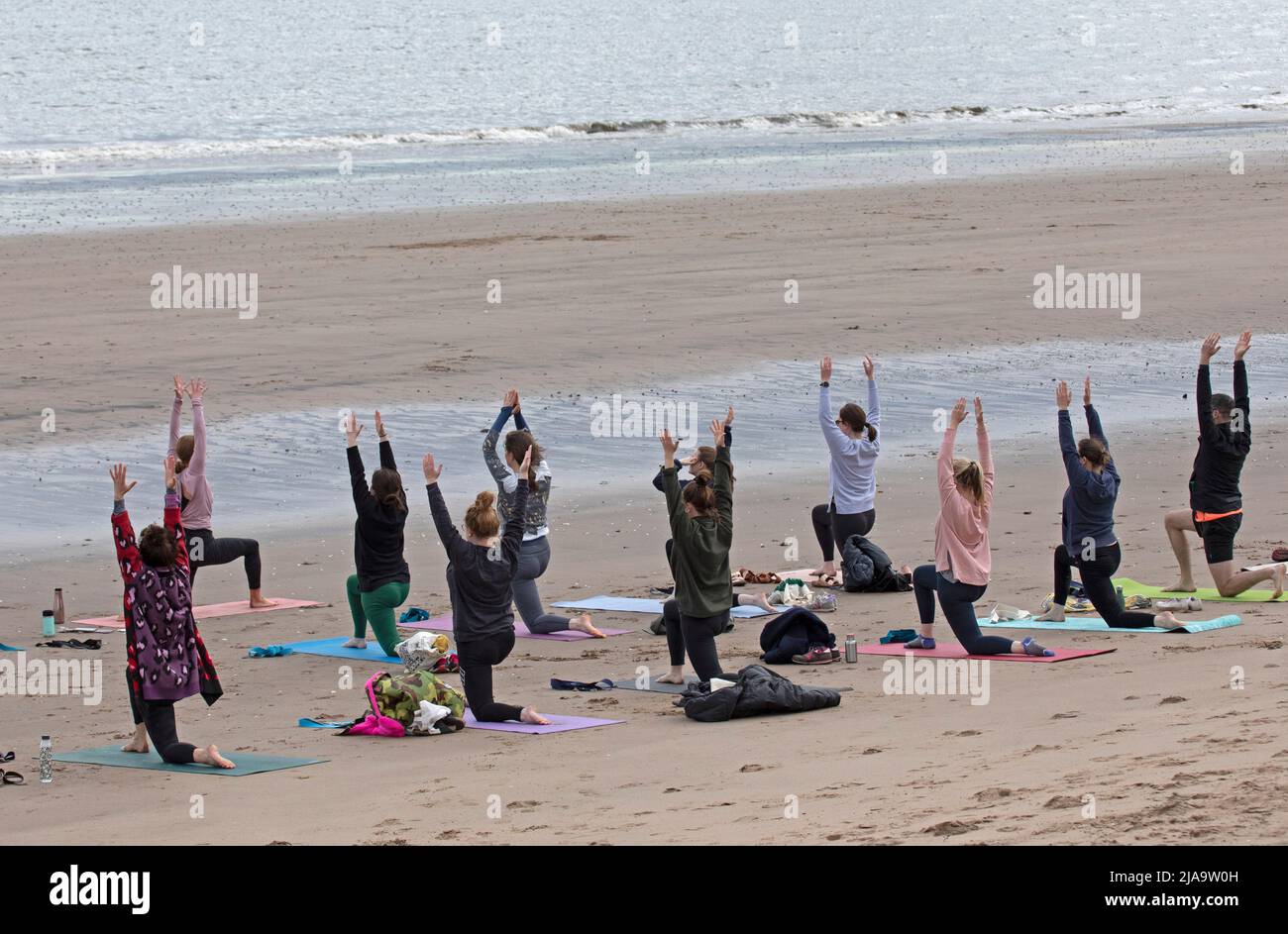 Portobello, Edinburgh Schottland, Großbritannien. 29. Mai 2022. Yoga-Übungen am Sandstrand. Temperatur ca. 9 Grad Celsius. Stockfoto