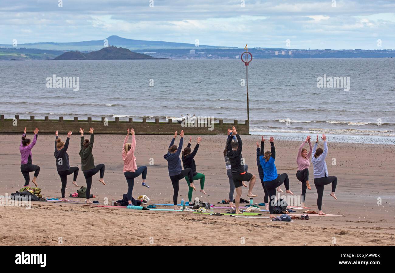 Portobello, Edinburgh Schottland, Großbritannien. 29. Mai 2022. Yoga-Übungen am Sandstrand. Temperatur ca. 9 Grad Celsius. Stockfoto