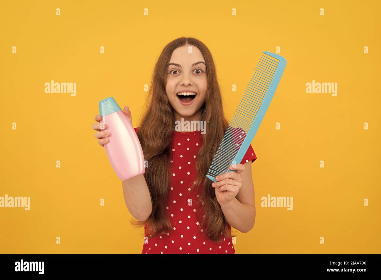 Stauned teen girl hat lange Haare halten Haarbürste und Lotion, selektive Fokus, tägliche Gewohnheit. Stockfoto