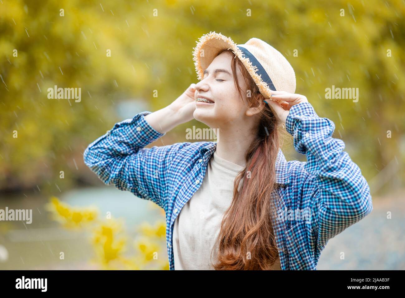 Nette junge schöne Brünette teen Mädchen glücklich lächelnd im Freien regnet Saison Stockfoto