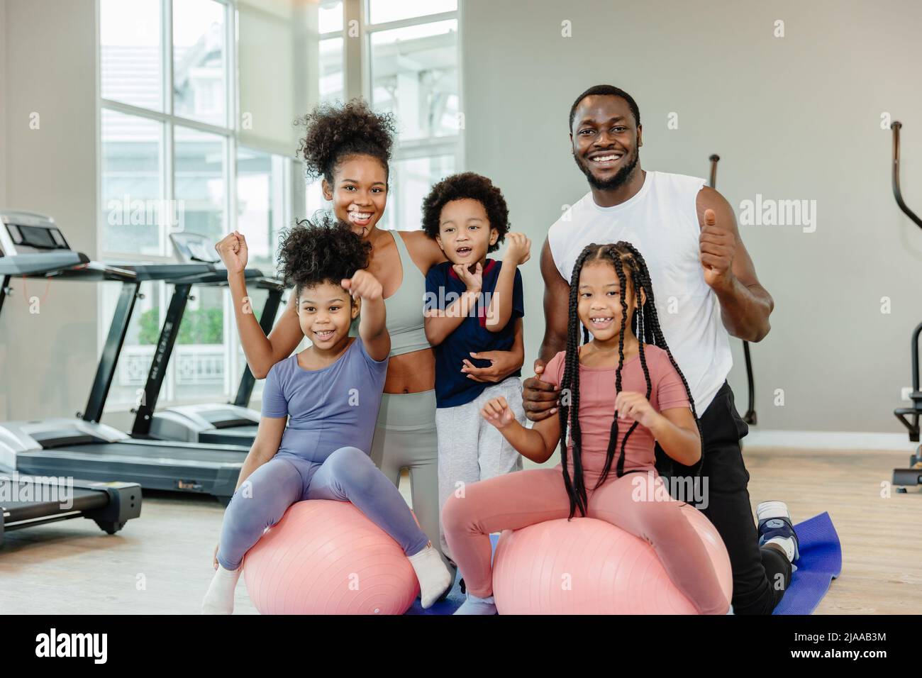 Gesunde schwarze Familienkinder und Eltern trainieren gemeinsam im Fitness-Sportclub. Stockfoto