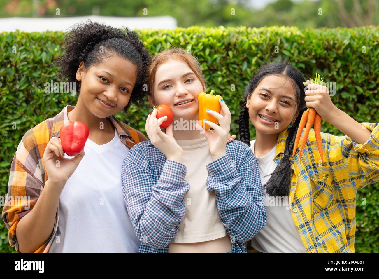 Teen Mädchen mischen Rennen glücklich Lächeln mit Gemüse frisch aus der Landwirtschaft Essen gesund Konzept Stockfoto